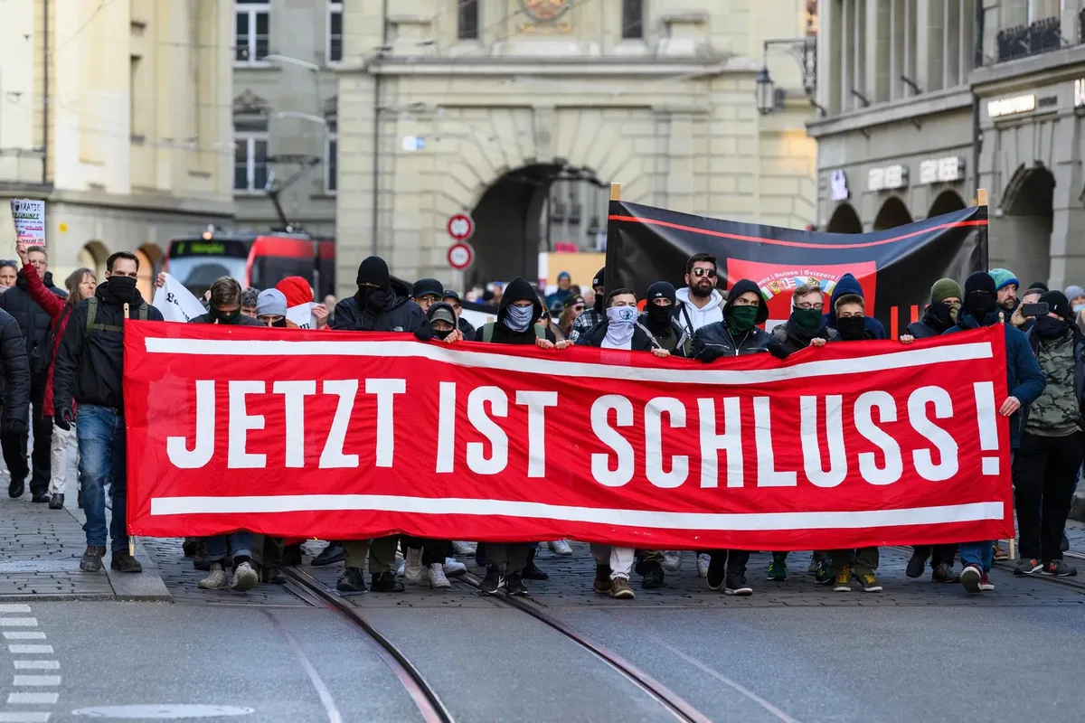 Man sieht Menschen mit einem Riesigen Banner mit "Jetzt ist Schluss".